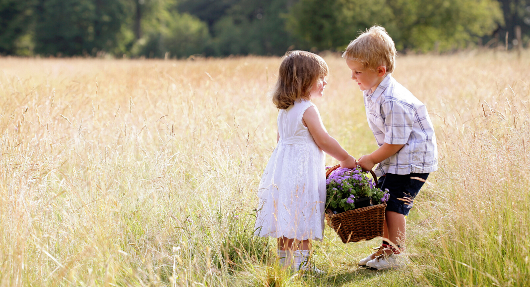 boy carrying basket of flowers for girl, showing kindness, lessons from Mister Rogers