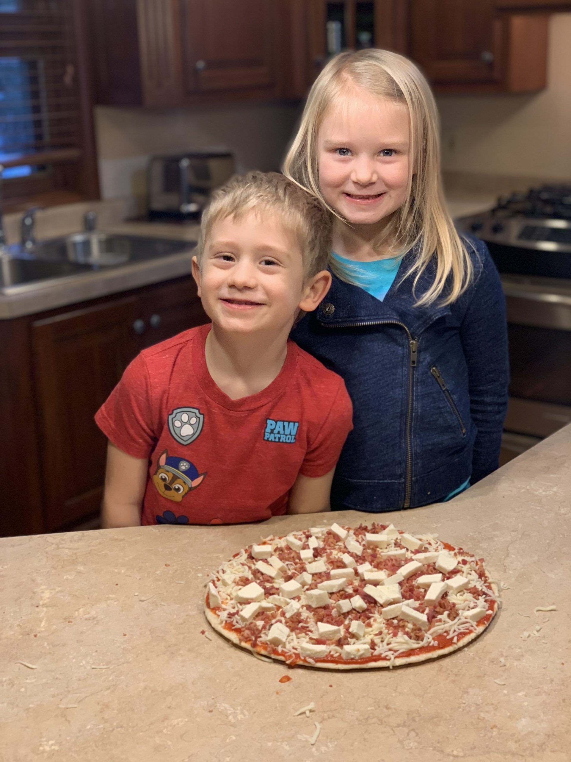 Kids showing off their Crustology pizza creation.