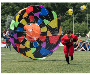 Superhero running with parachute at Kite Fest